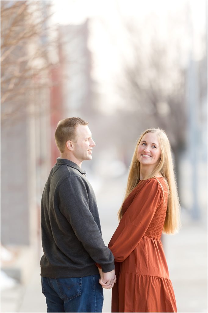 Engaged couple walking Downtown Sioux Falls during winter